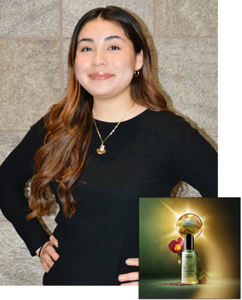 A woman with long brown hair in a black top stands against a stone wall. Inset shows a skincare product bottle with flowers and peppercorns on a green background. - Nuovo Salon Group in Sarasota & Bradenton, FL